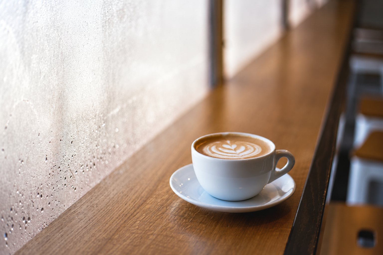 Tasse de café latte avec motif sur un comptoir en bois